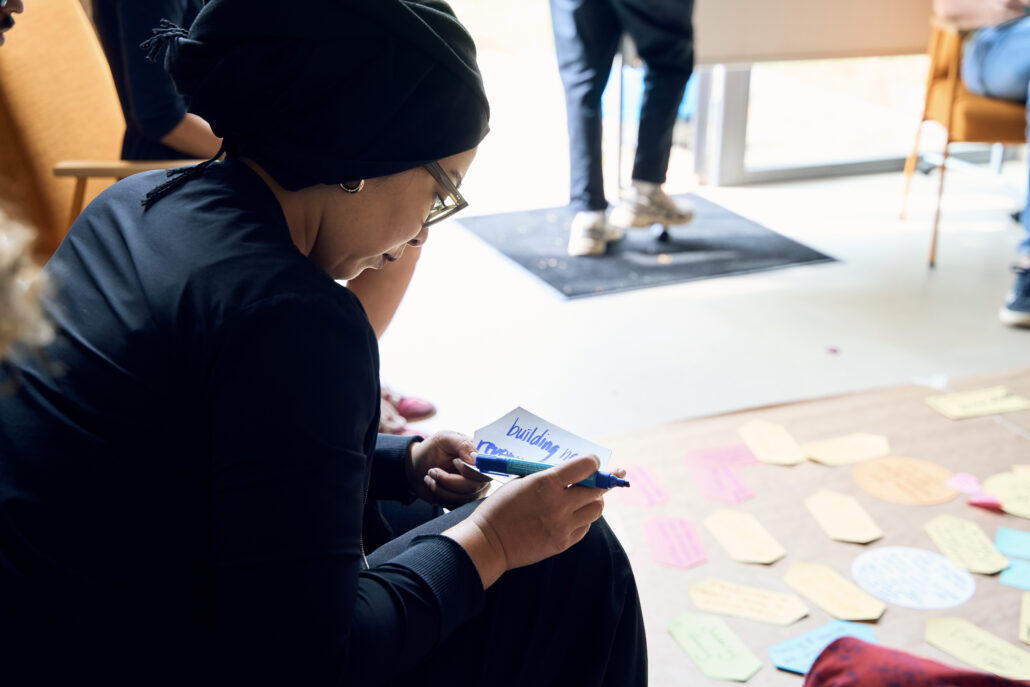 Changemaker writing something on a card during a discussion